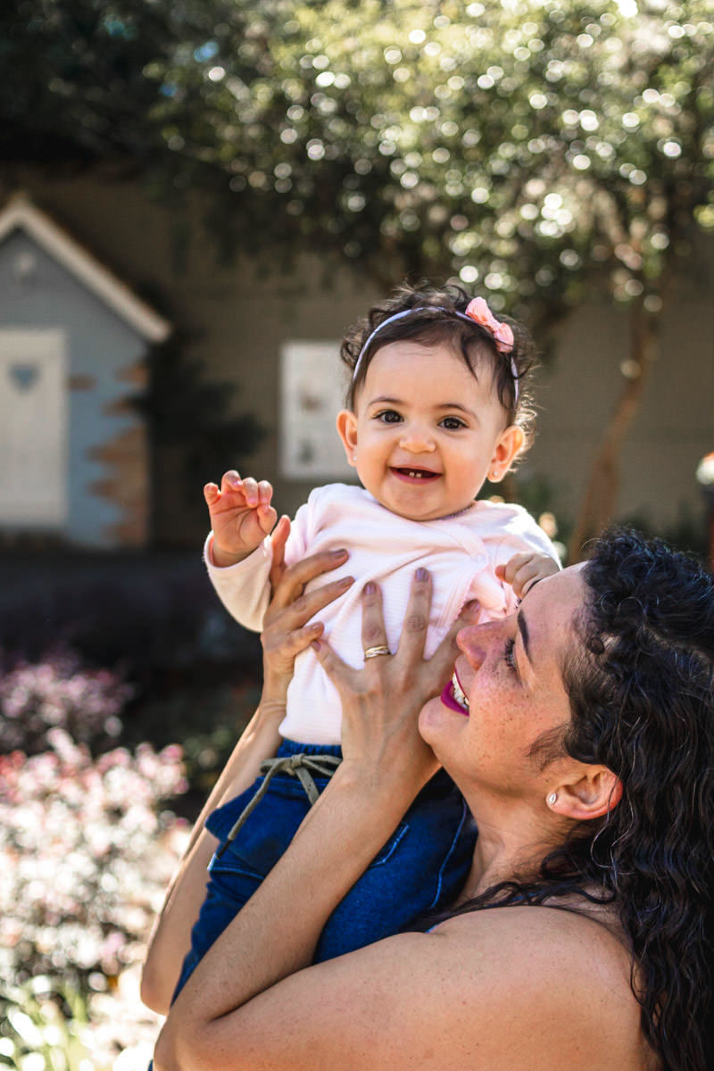 mãe levantando a filha no colo