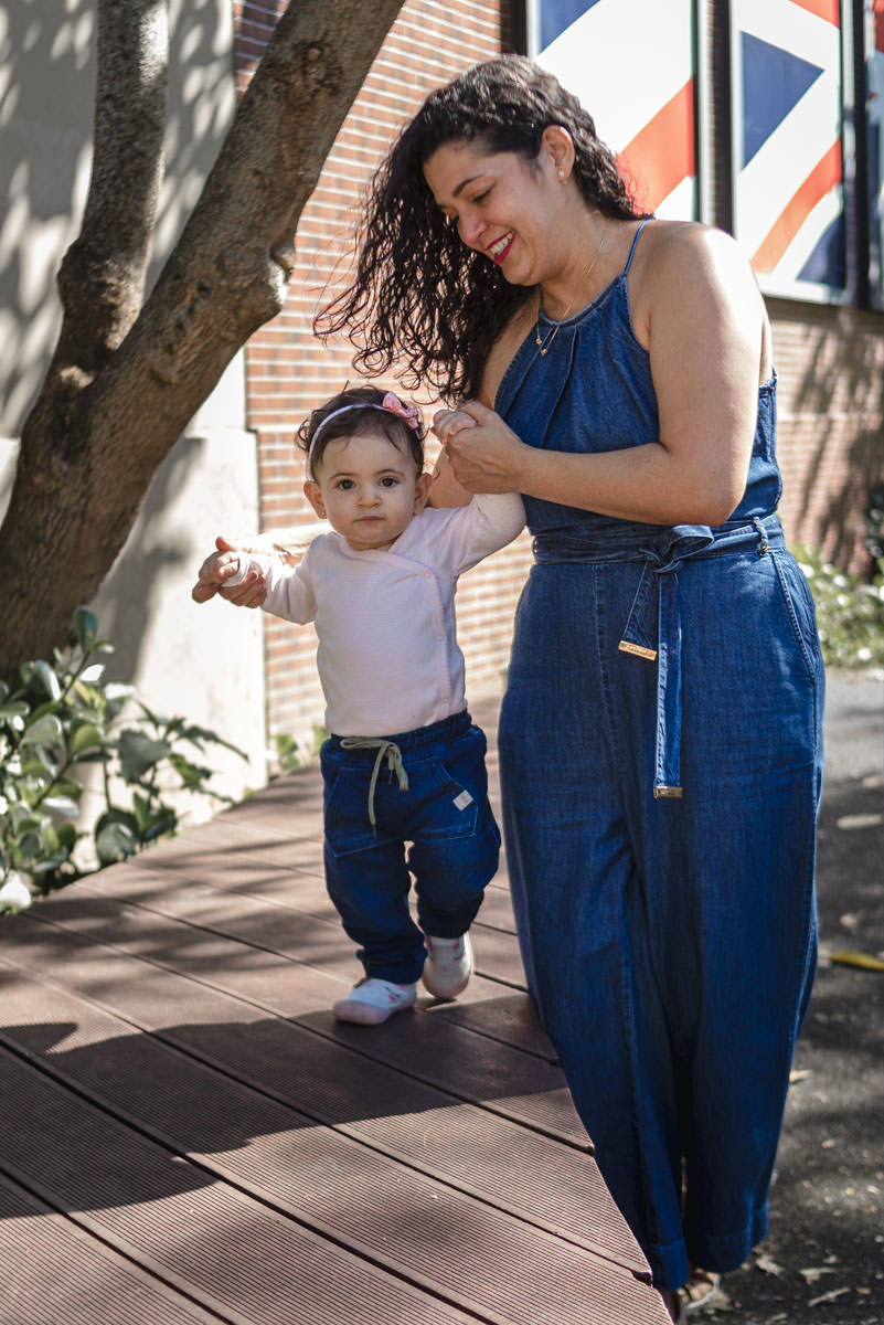 bebê caminhando de mãos dada com a mãe