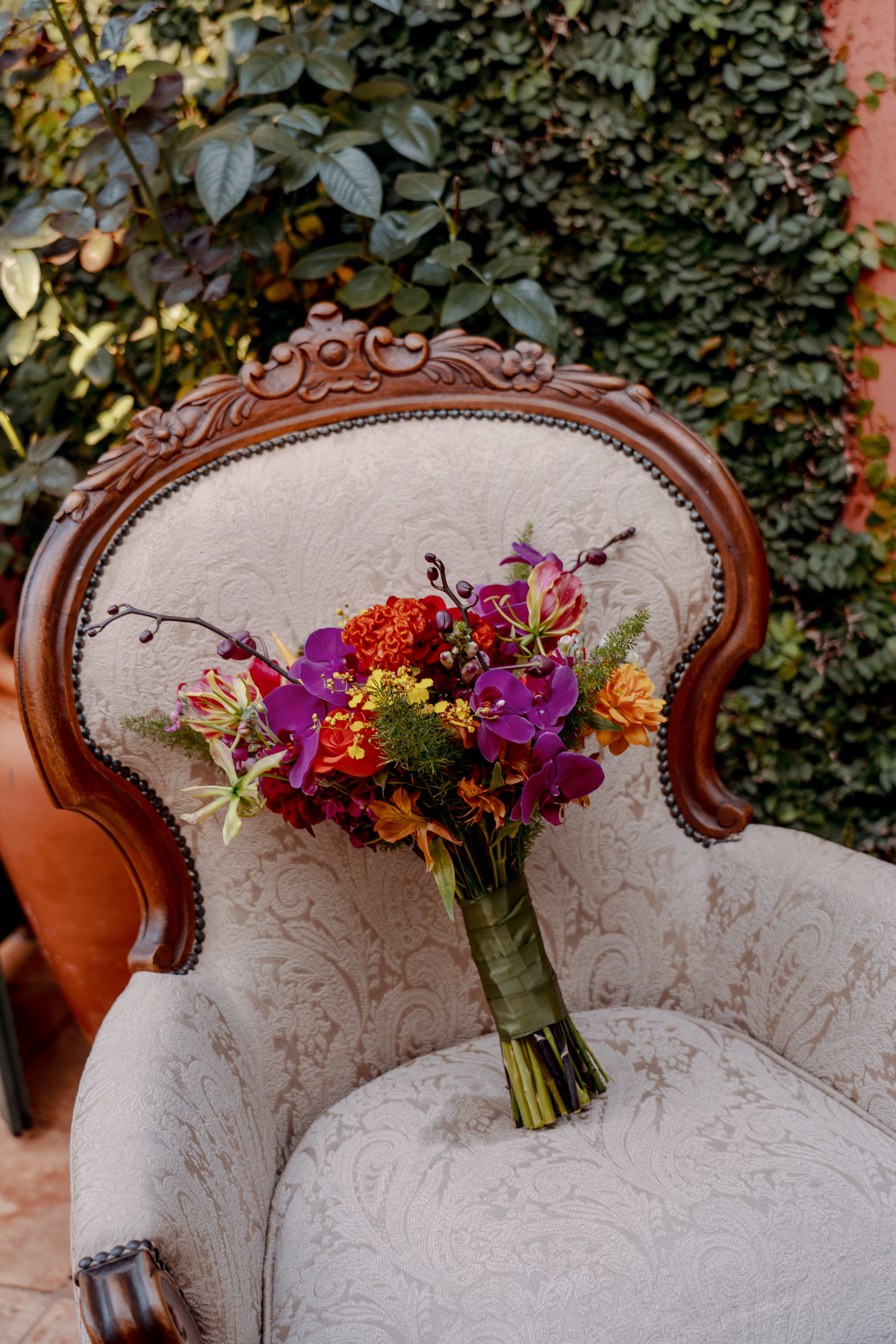 Arranjo floral sobre uma poltrona decorativa, compondo a ambientação do casamento.