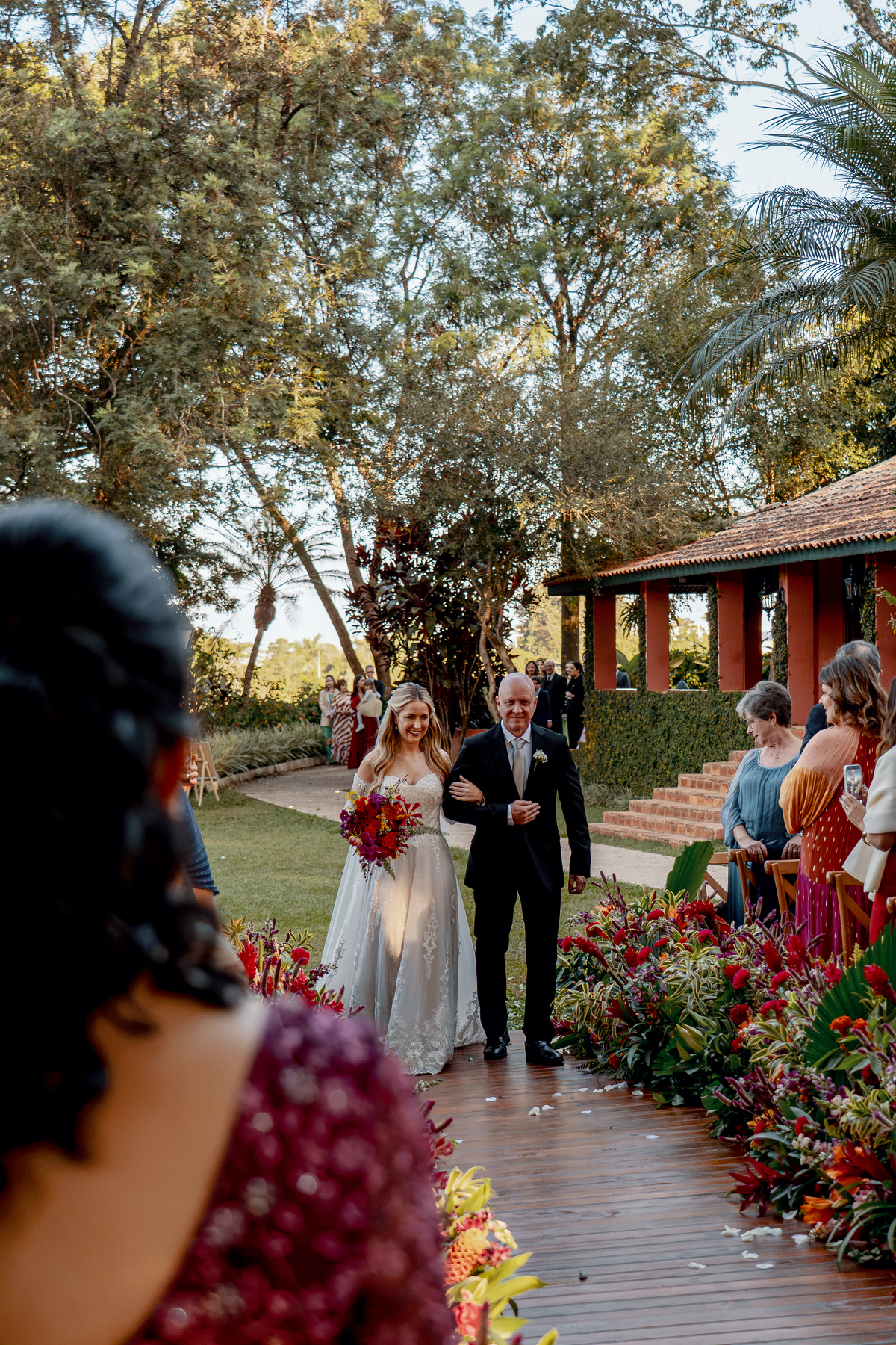 6. Noivos caminhando pelo corredor entre familiares e amigos.
