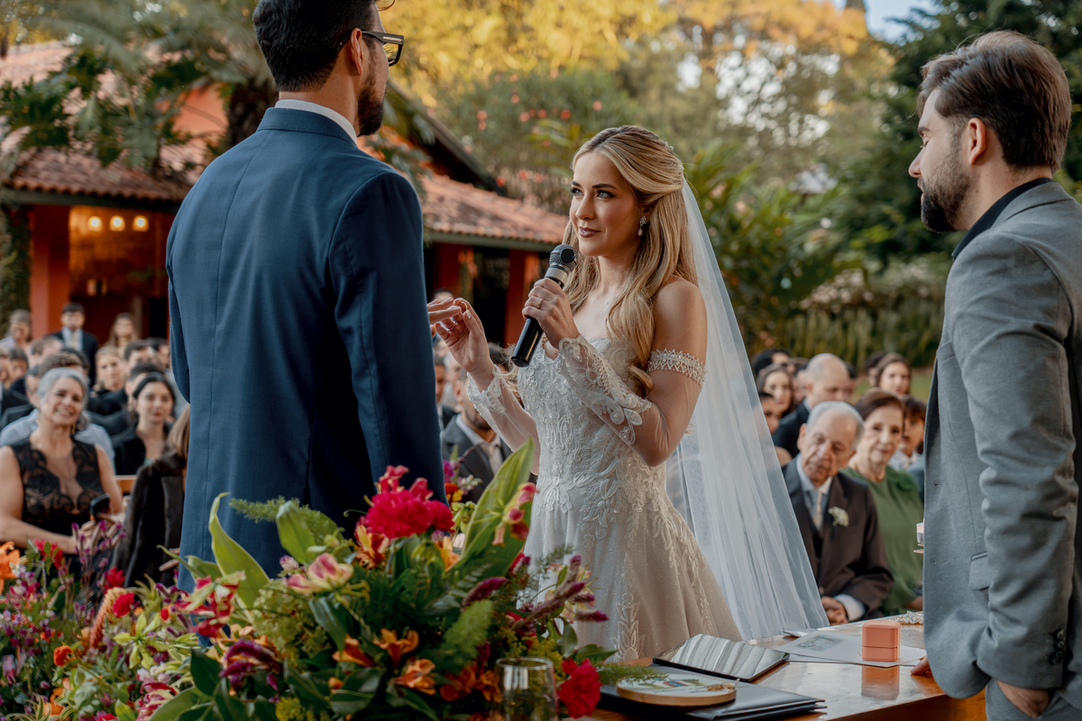 10. Noivos diante do celebrante e dos convidados em um momento da cerimônia.
