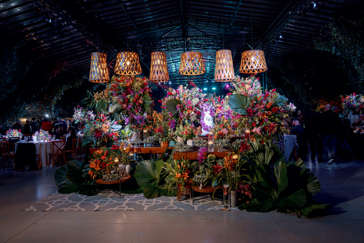 Mesa de doces e arranjos florais compondo a decoração da recepção.