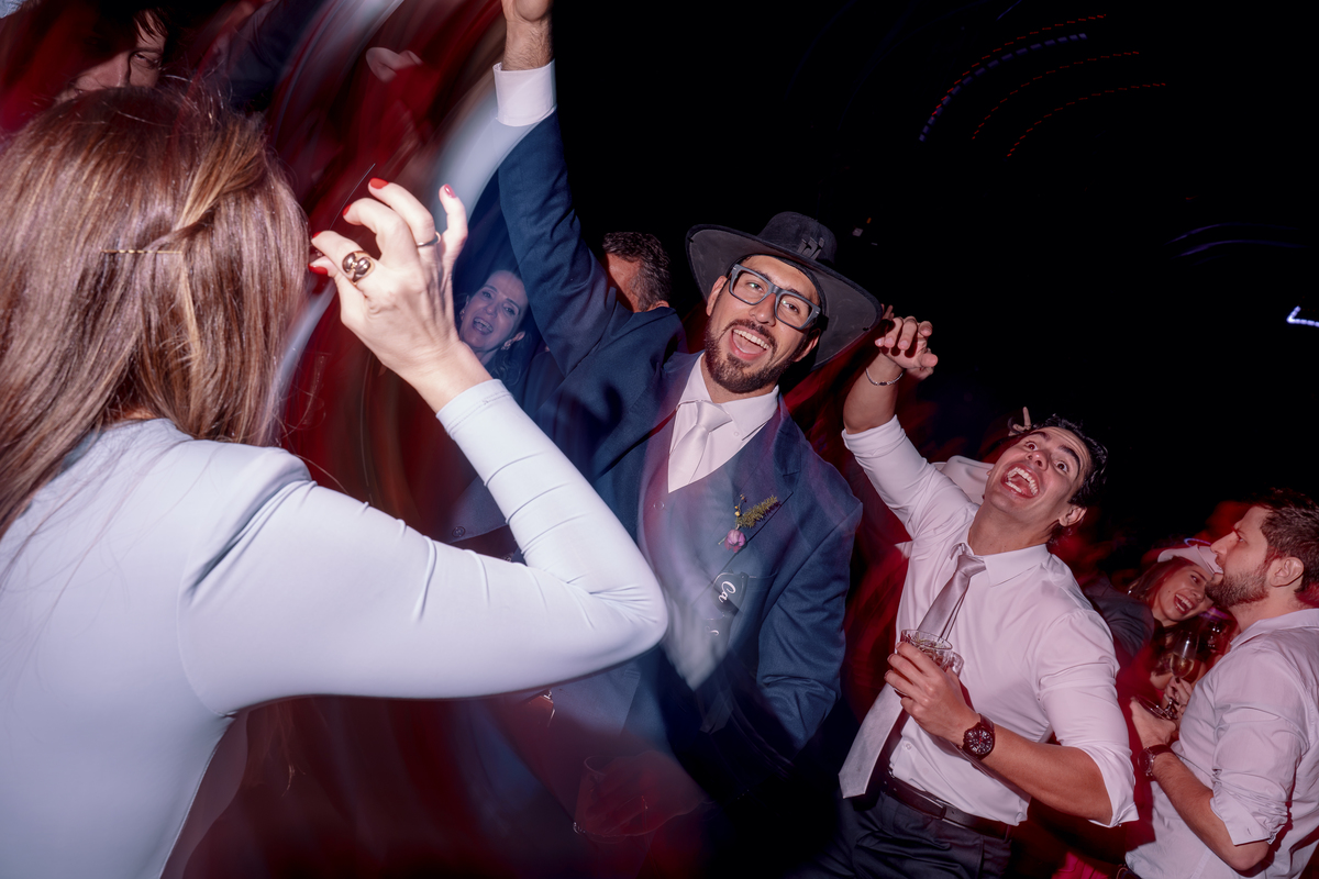 Convidados dançando e interagindo com os noivos durante a recepção.