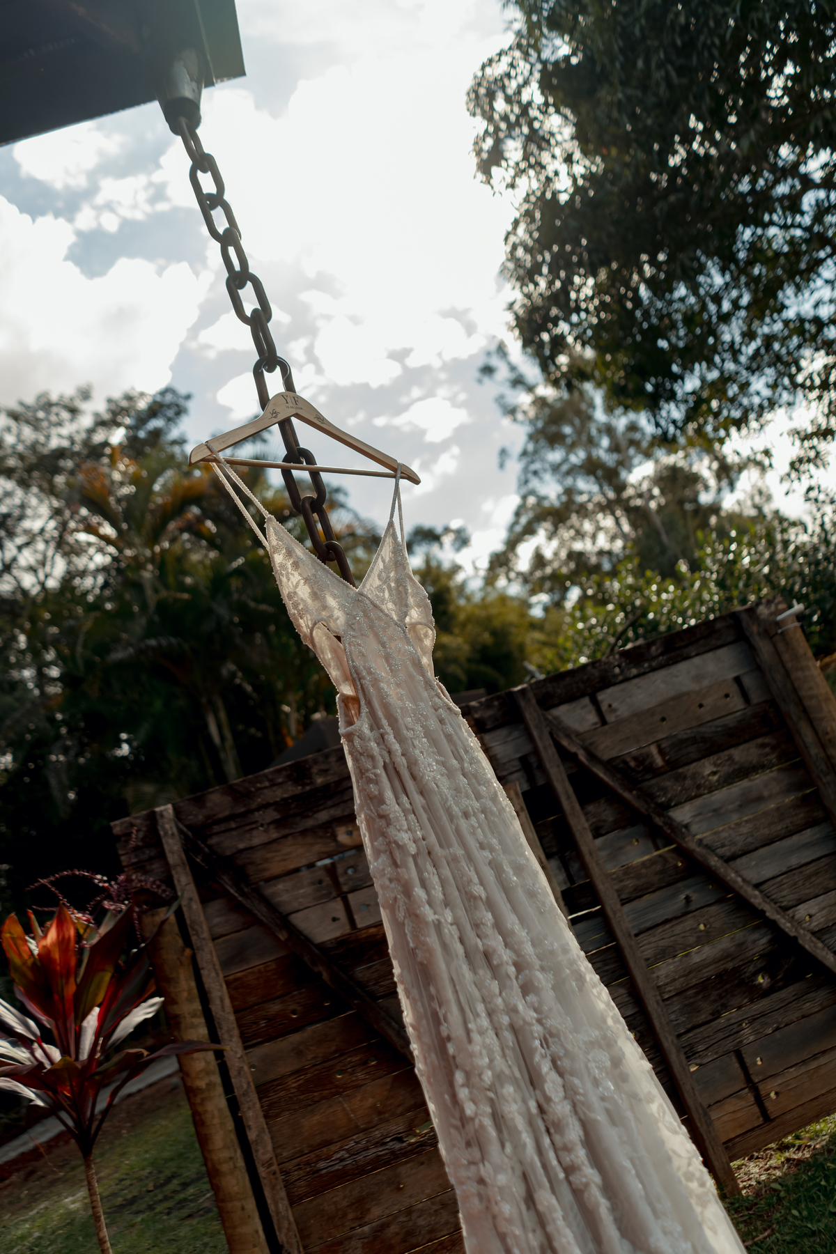 Vestido de noiva de Yasmin fotografado ao ar livre na Fazenda Vila dos Eucaliptos, cercado pela natureza e pela atmosfera de um casamento no campo.