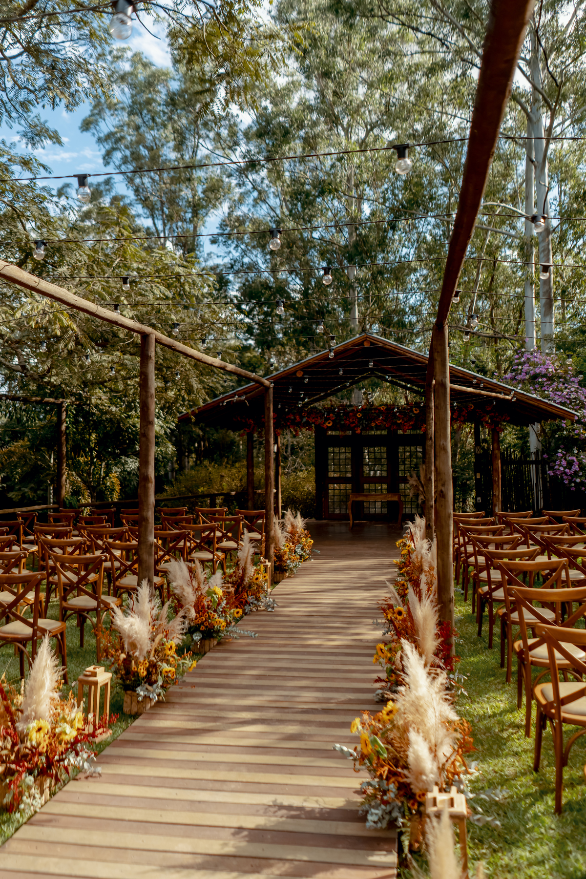 Cerimônia de casamento ao ar livre na Fazenda Vila dos Eucaliptos, com decoração rústica e floral integrada à paisagem natural.