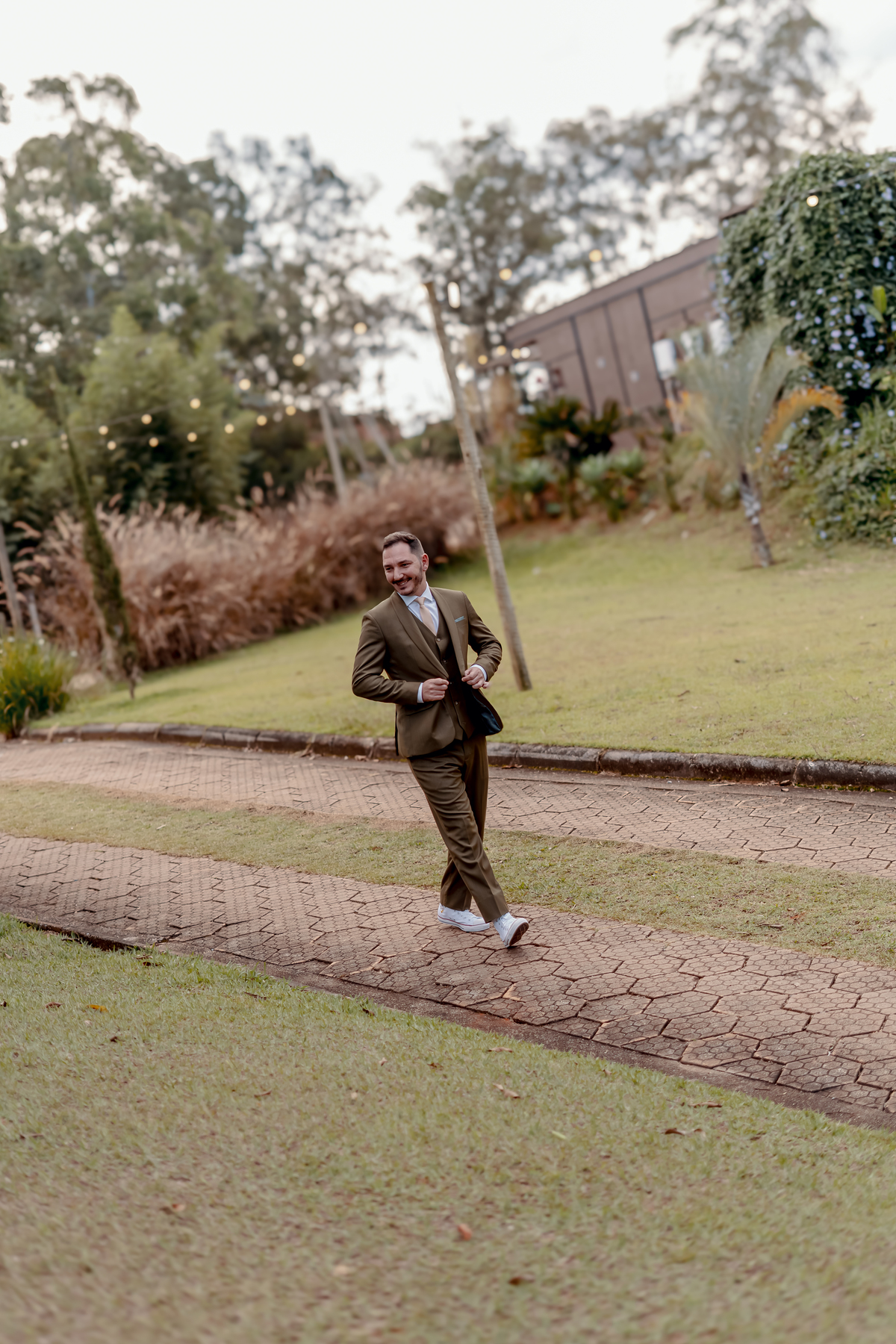 Fábio aguardando o início da cerimônia ao ar livre, em meio à natureza da Fazenda Vila dos Eucaliptos, durante o casamento de dia.