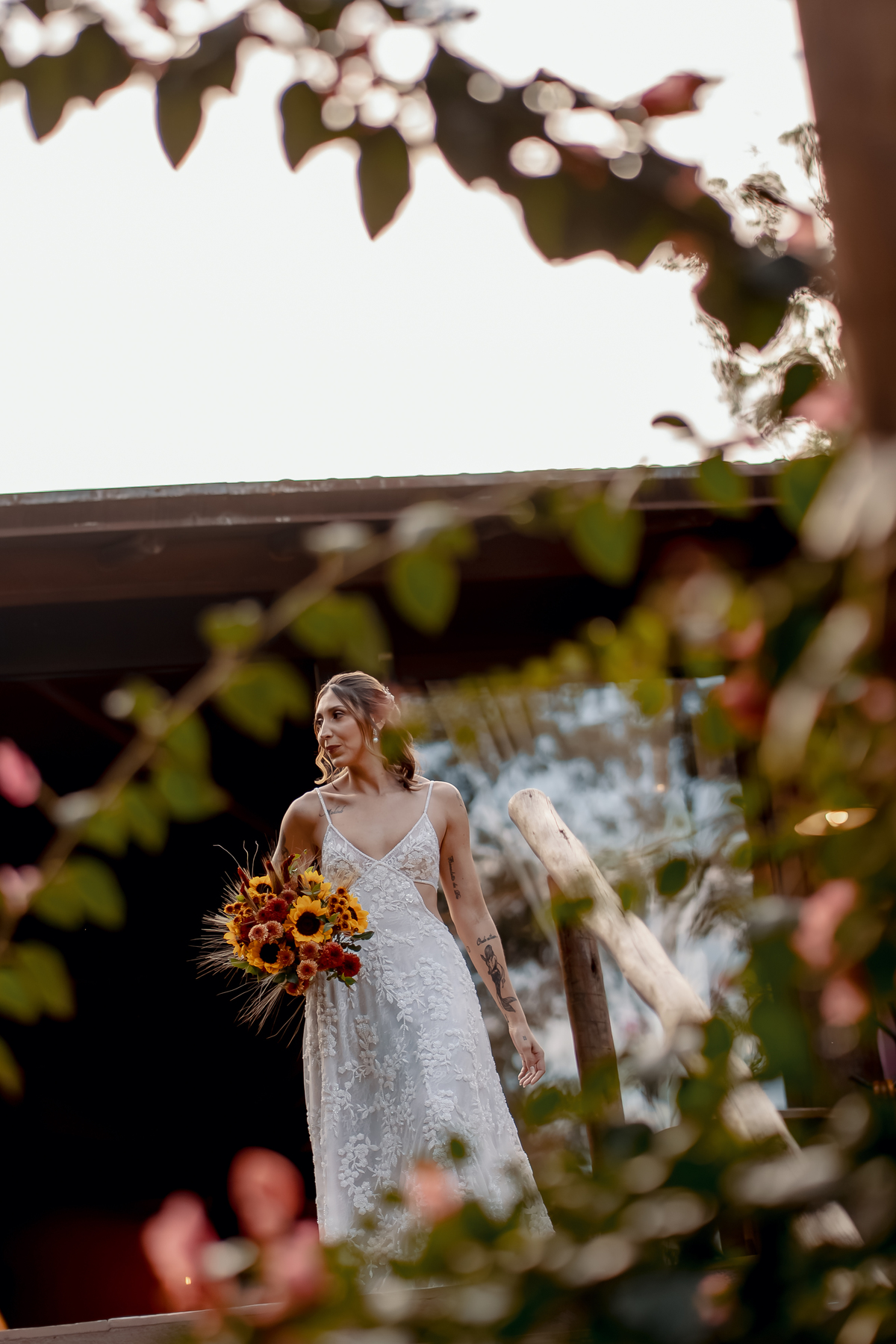 Yasmin durante a cerimônia ao ar livre, fotografada entre a vegetação e a luz natural do casamento realizado no campo