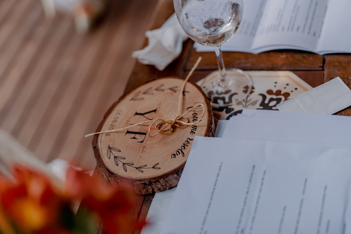 Detalhe dos elementos utilizados na cerimônia, com alianças e objetos pessoais compondo uma fotografia de memória do casamento.
