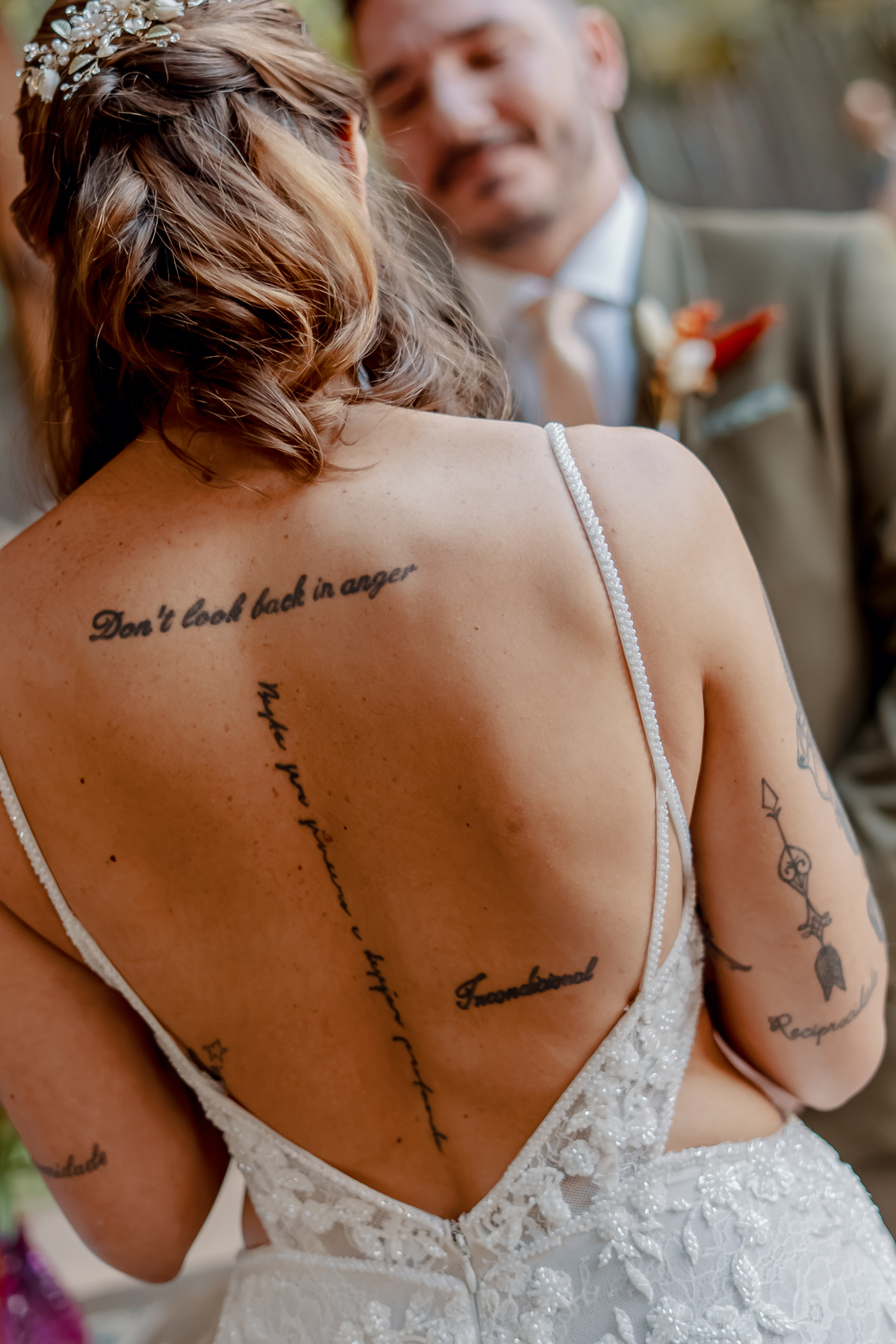 Detalhe das costas de Yasmin, revelando seu vestido e uma tatuagem durante a cerimônia na Fazenda Vila dos Eucaliptos.