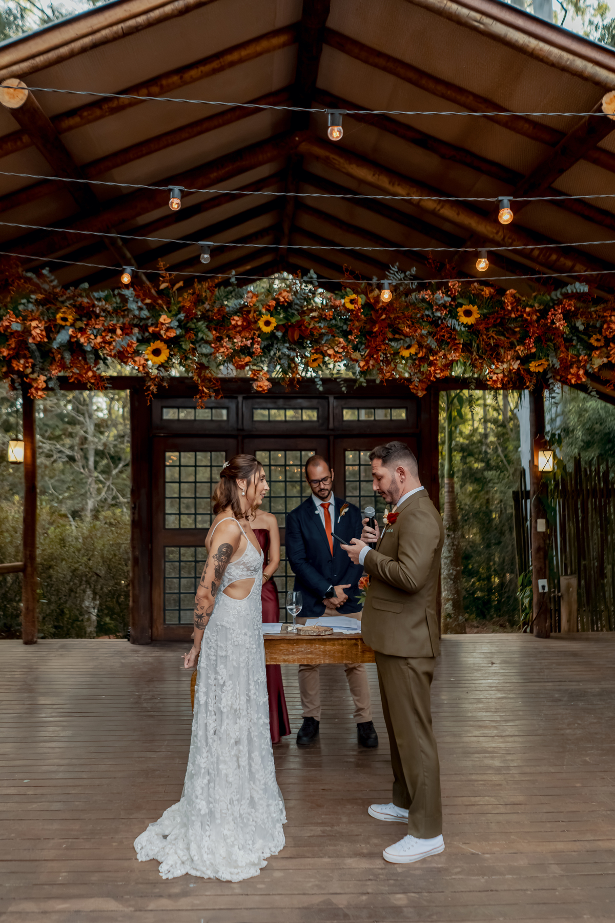 Fábio e Yasmin durante a celebração na Fazenda Vila dos Eucaliptos, em meio à decoração floral que marca o cenário do casamento no campo.