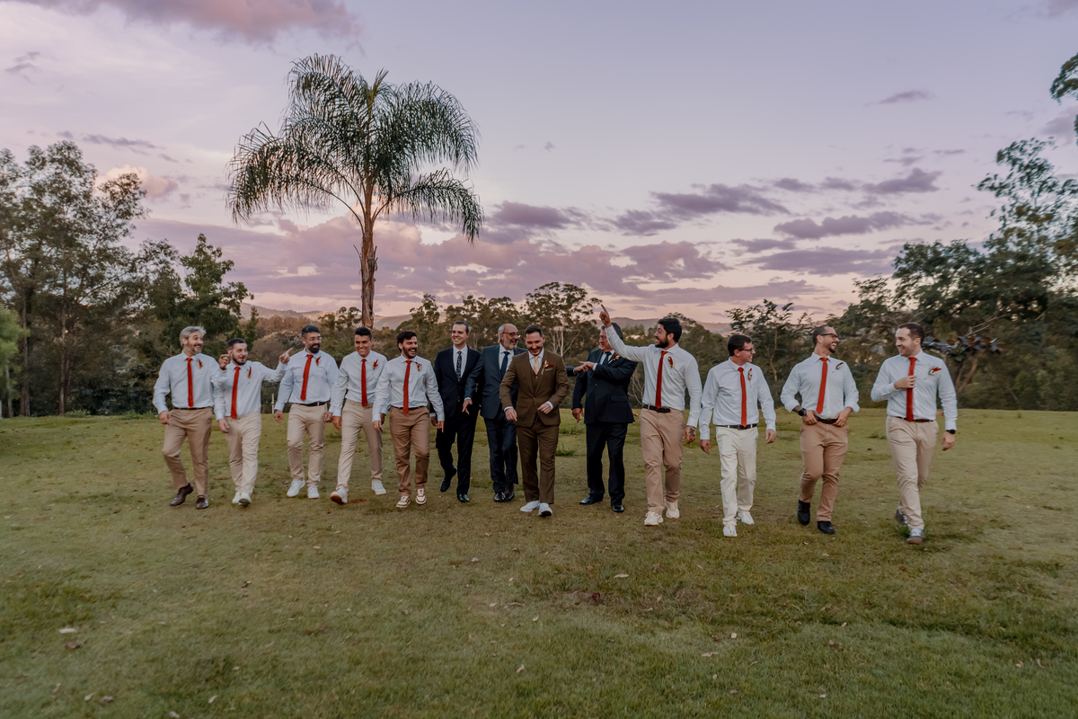 Fábio ao lado dos padrinhos em um retrato de grupo no gramado, aproveitando a paisagem natural da Fazenda Vila dos Eucaliptos.