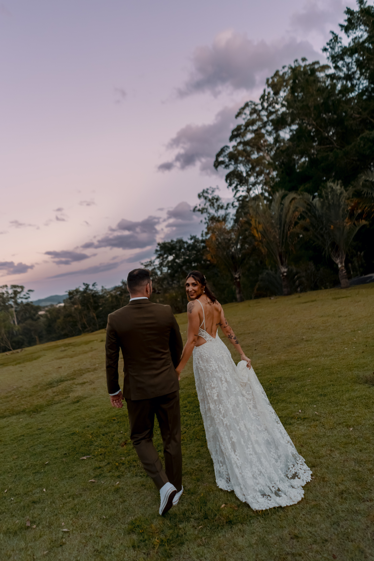 Fábio e Yasmin caminhando pela área externa da Fazenda Vila dos Eucaliptos, em um registro espontâneo dos recém-casados.