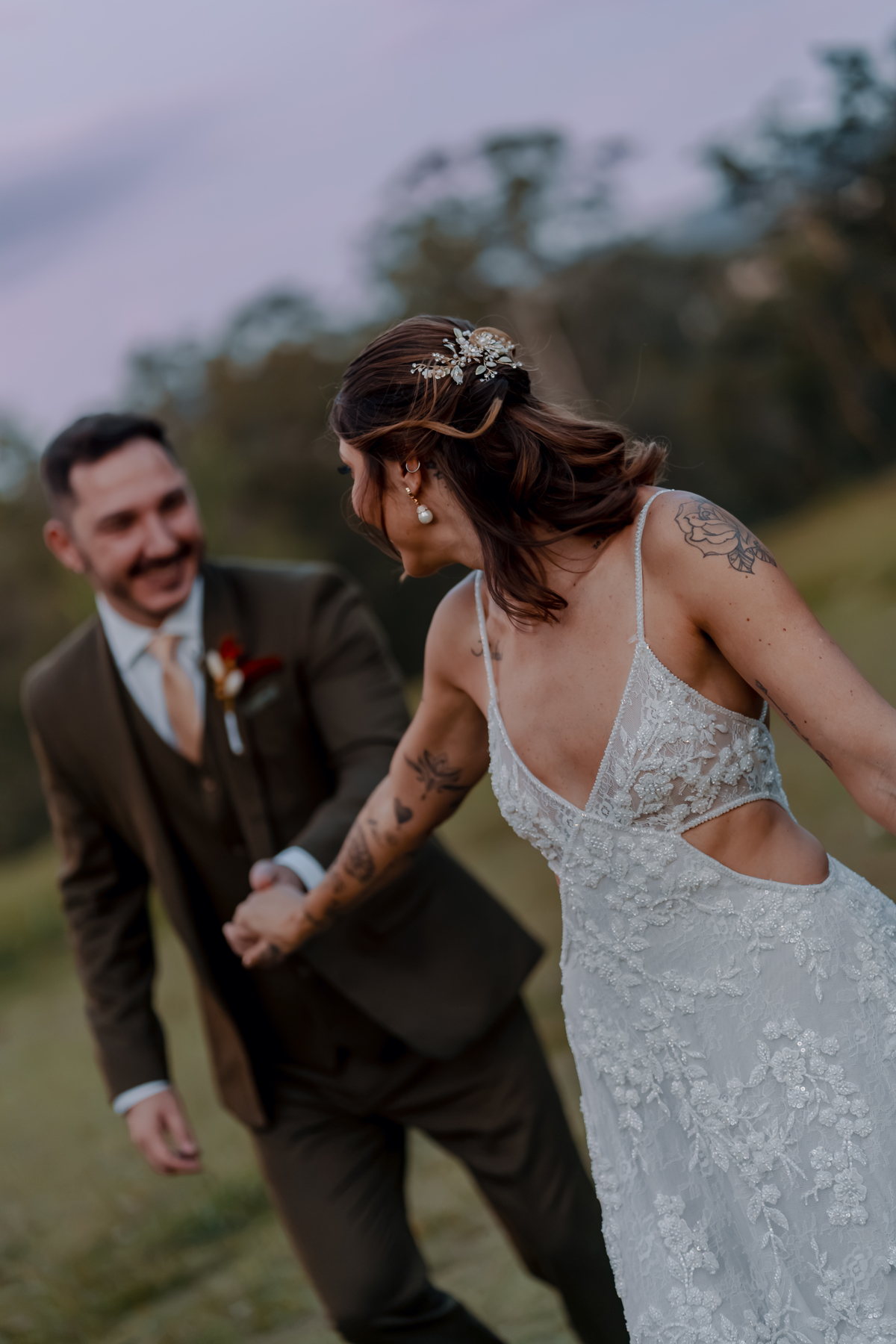 Fábio e Yasmin caminhando juntos após a cerimônia, em um momento espontâneo durante o ensaio de casal no campo.
