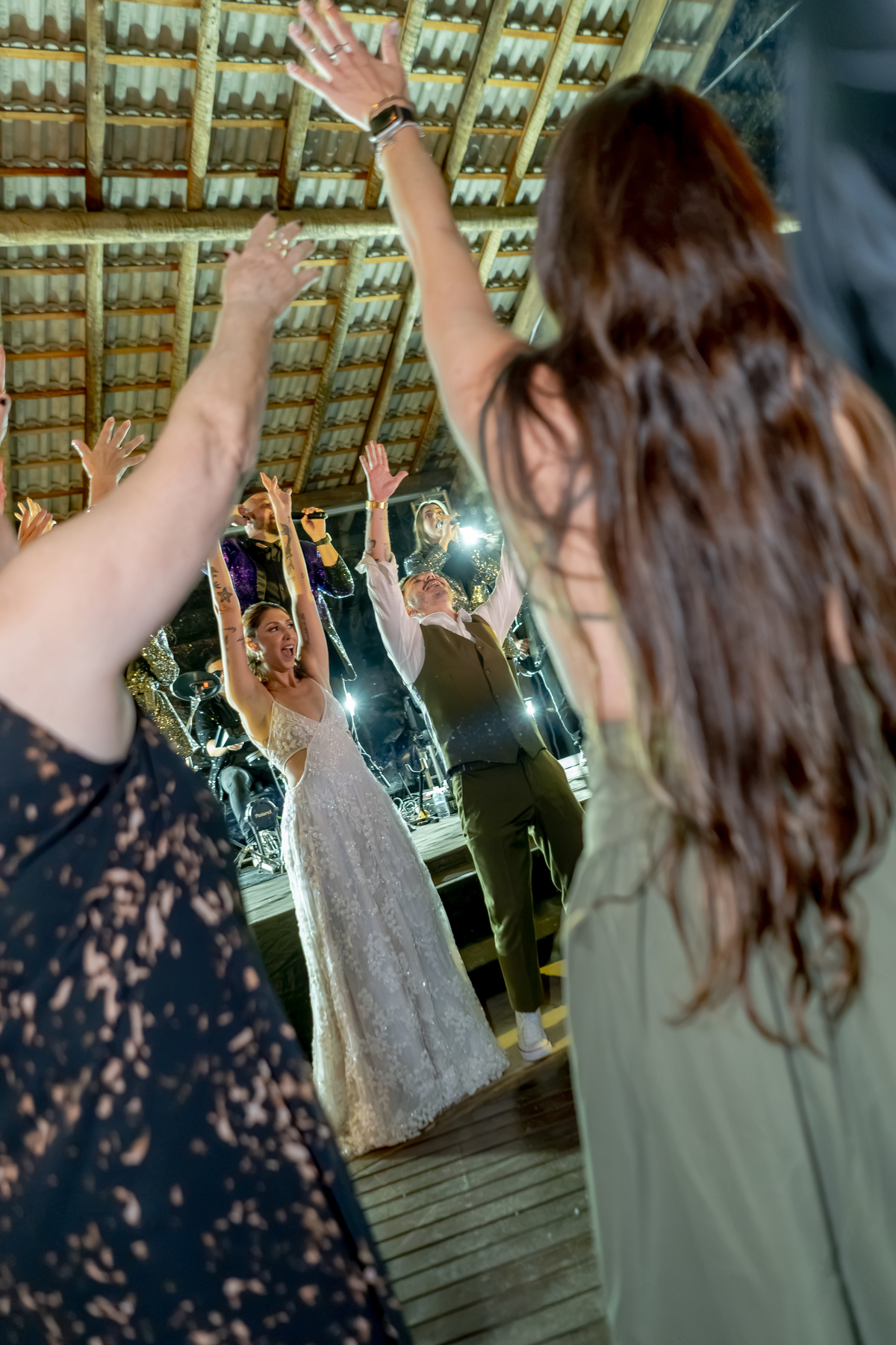 Convidados dançando e celebrando juntos durante a festa, em um momento espontâneo da recepção do casamento.
