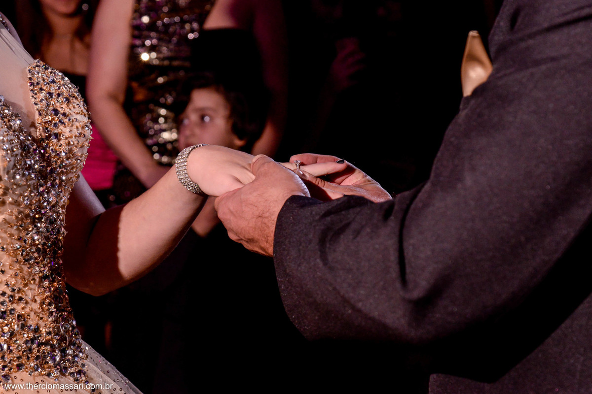 detalhe da mão da debutante enquanto o pai coloca o anel