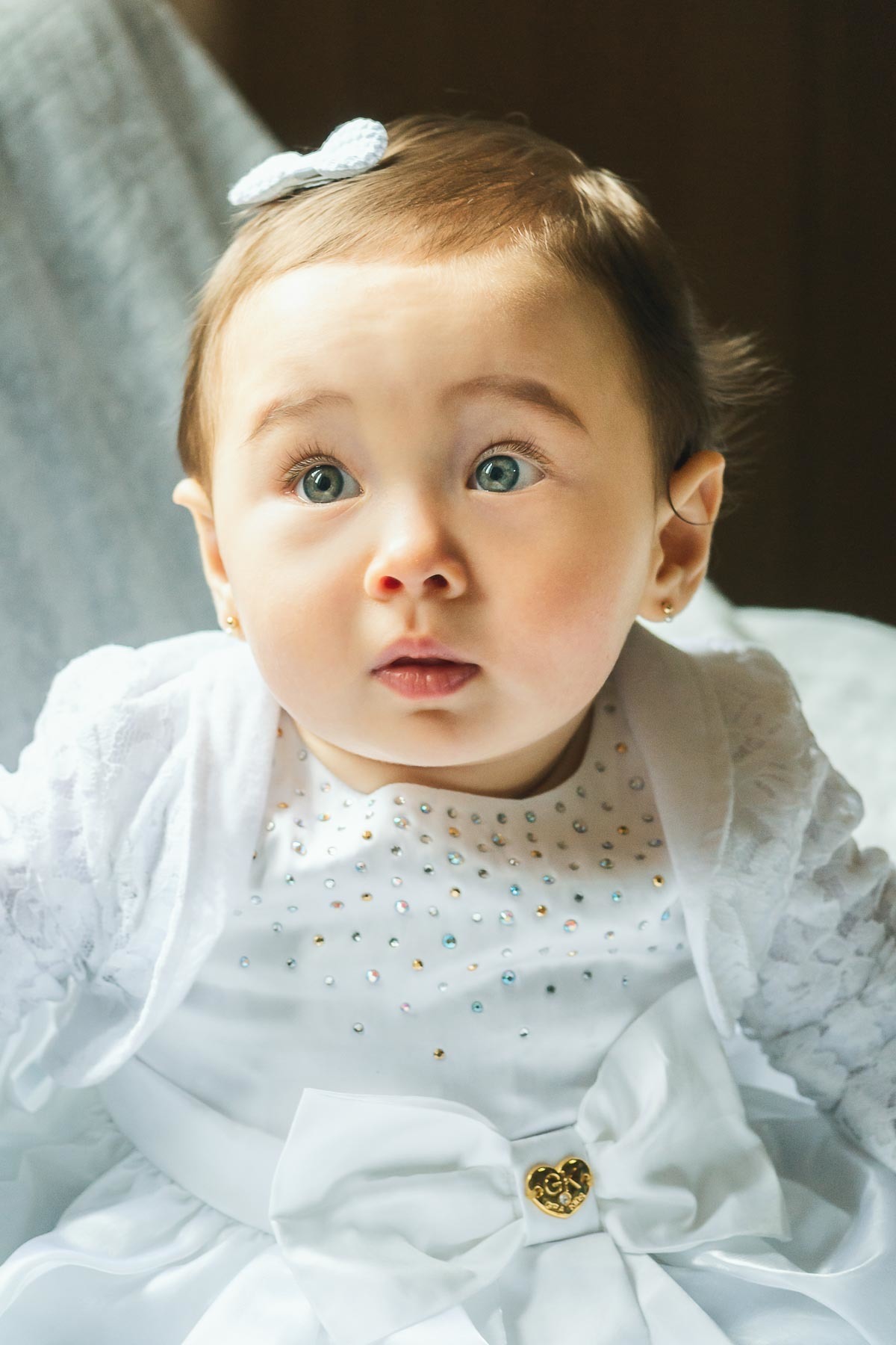 Bebê menina sendo arrumado para batismo