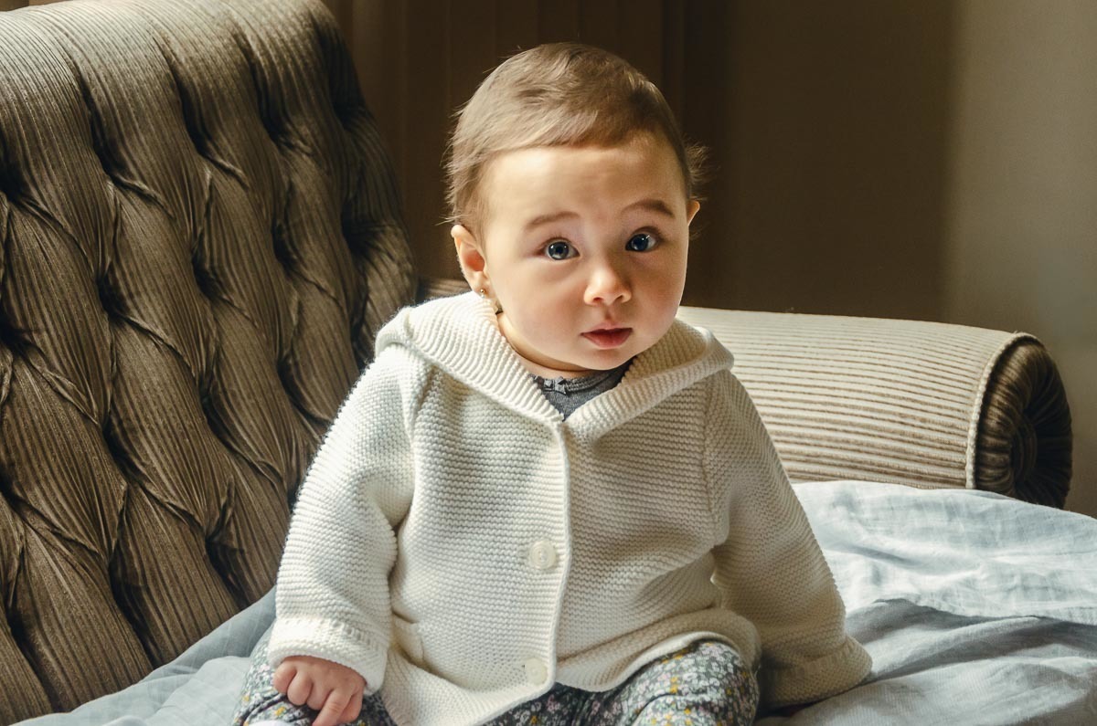 Bebê menina sendo arrumado para batismo