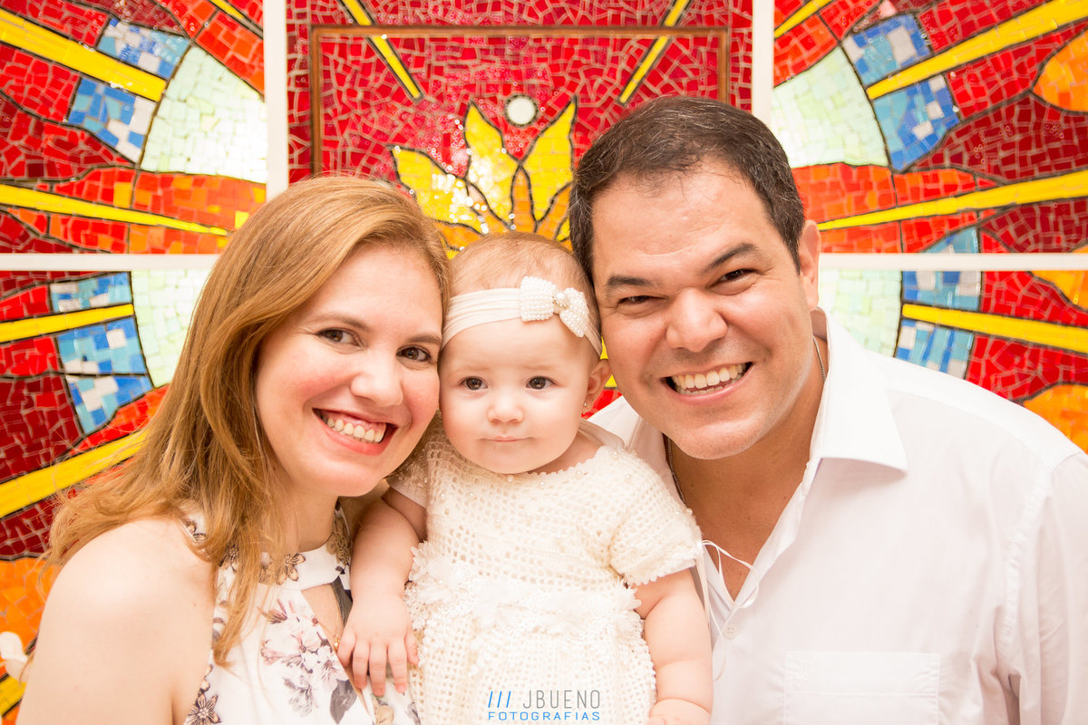 papai e mamãe da gabi sorrindo em seu batismo