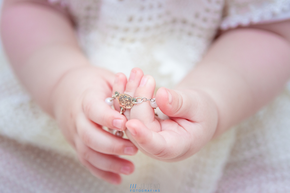 mãos pequenas de nenê segurando o terço