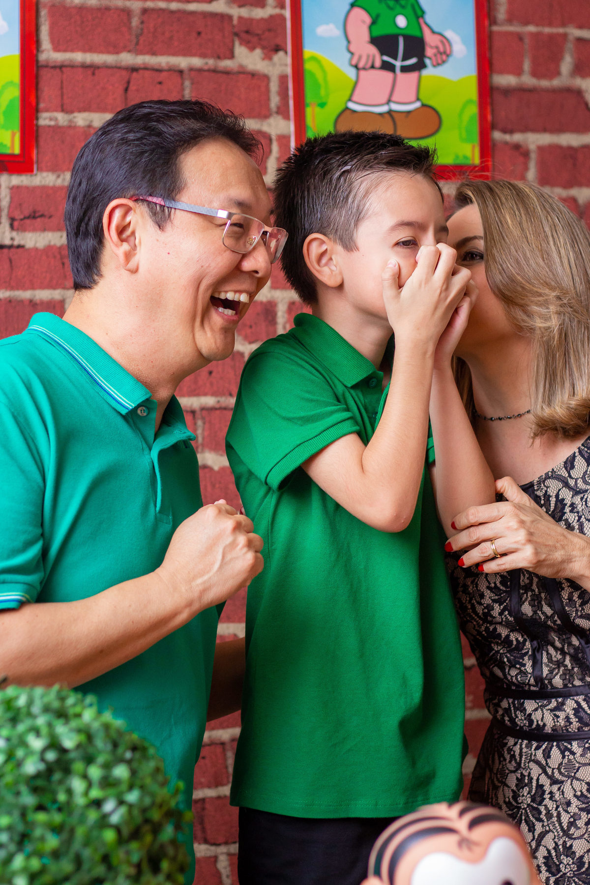 Foto espontânea na hora do parabéns, pais e filho rindo na mesa do bolo