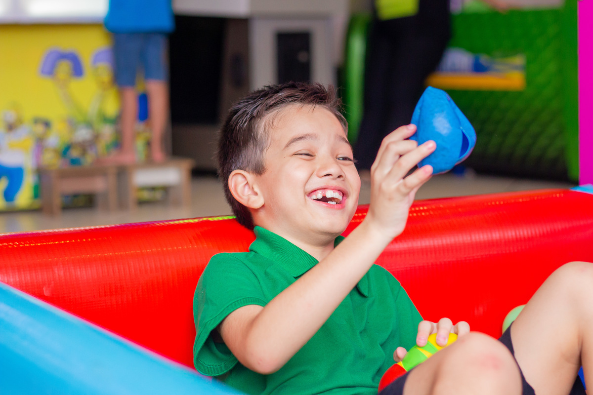 Aniversariante rindo na piscina de bolinhas