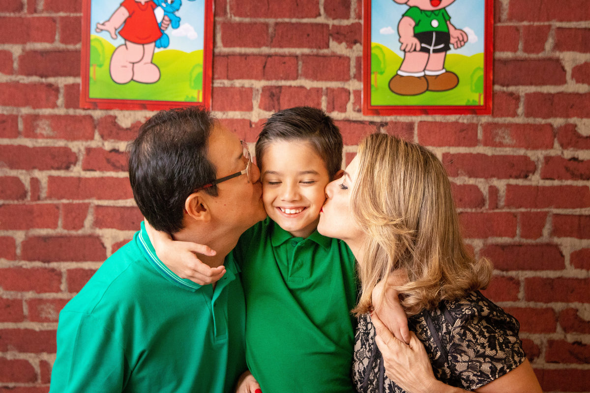 Fotos com os pais na mesa do bolo, pais dando um beijo no aniversariante