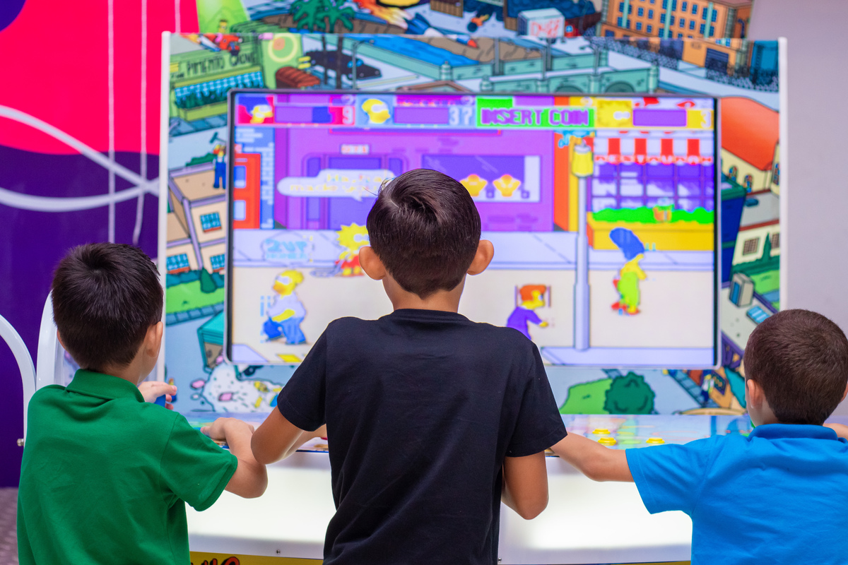 Aniversariante e seus amigos brincando no video game 