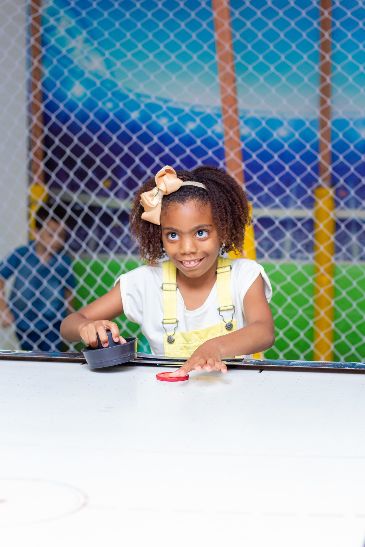 Menina se divertindo no air hockey