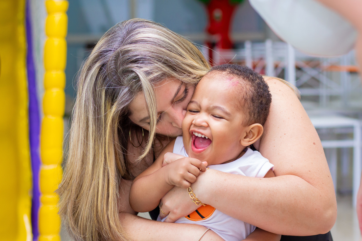 Aniversariante rindo ao receber carinho da tia