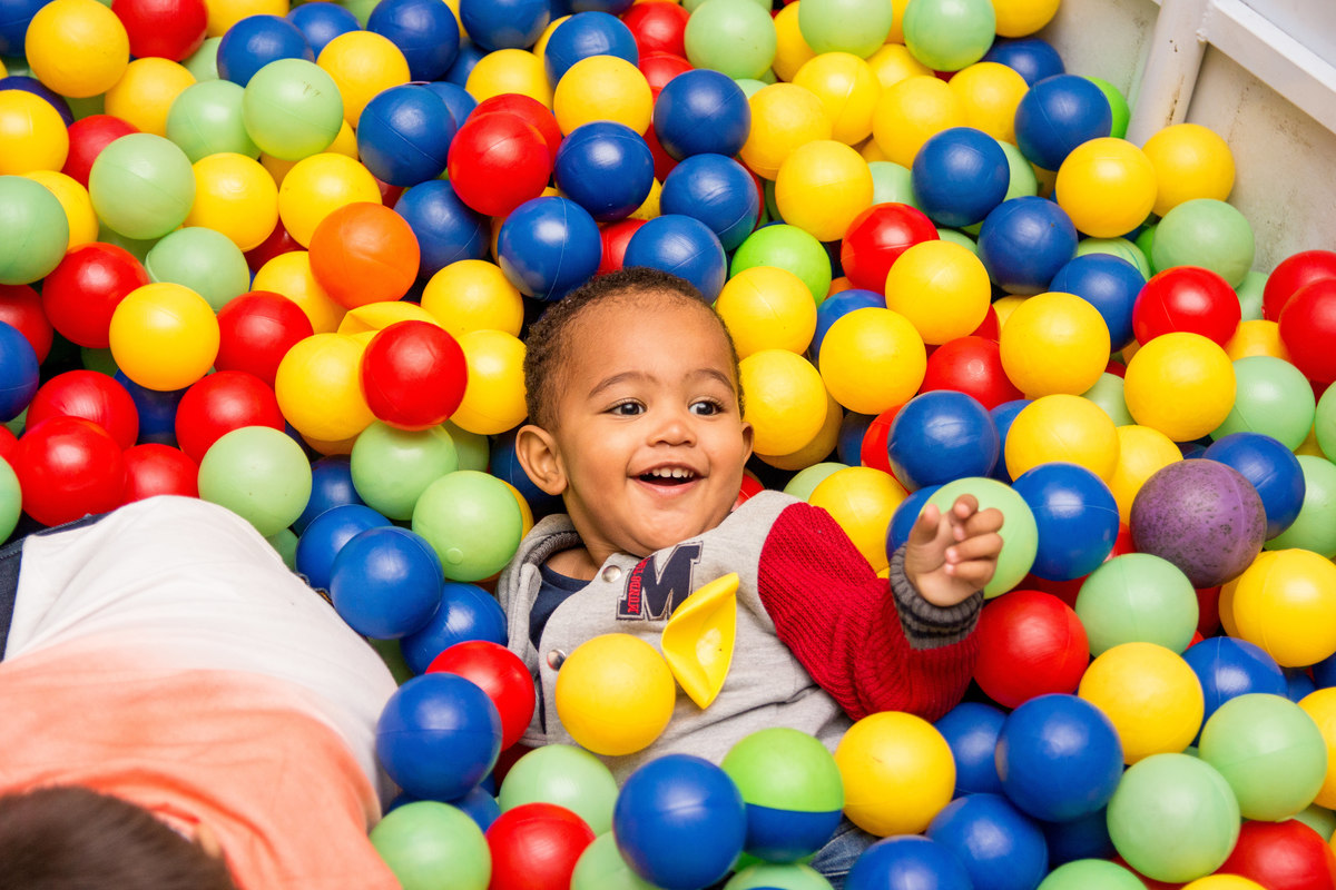 Menino brincando na piscina de bolinhas