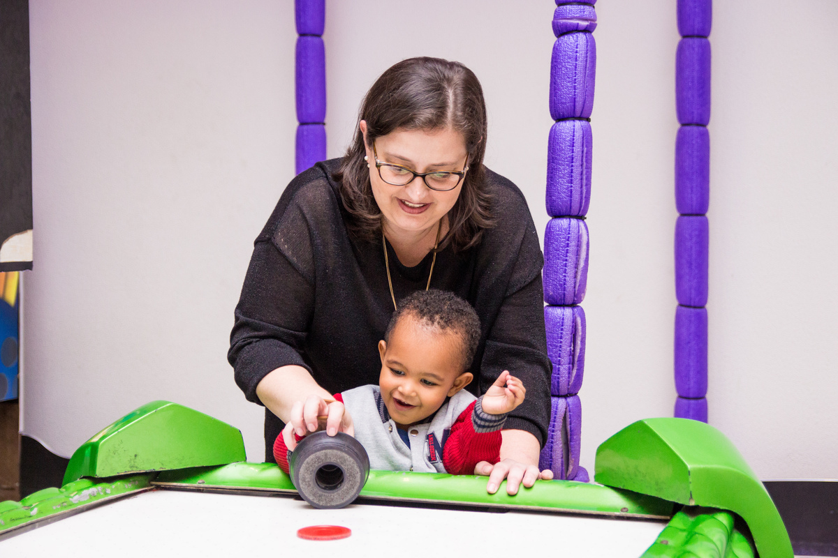 Mãe e filho brincando no air hockey
