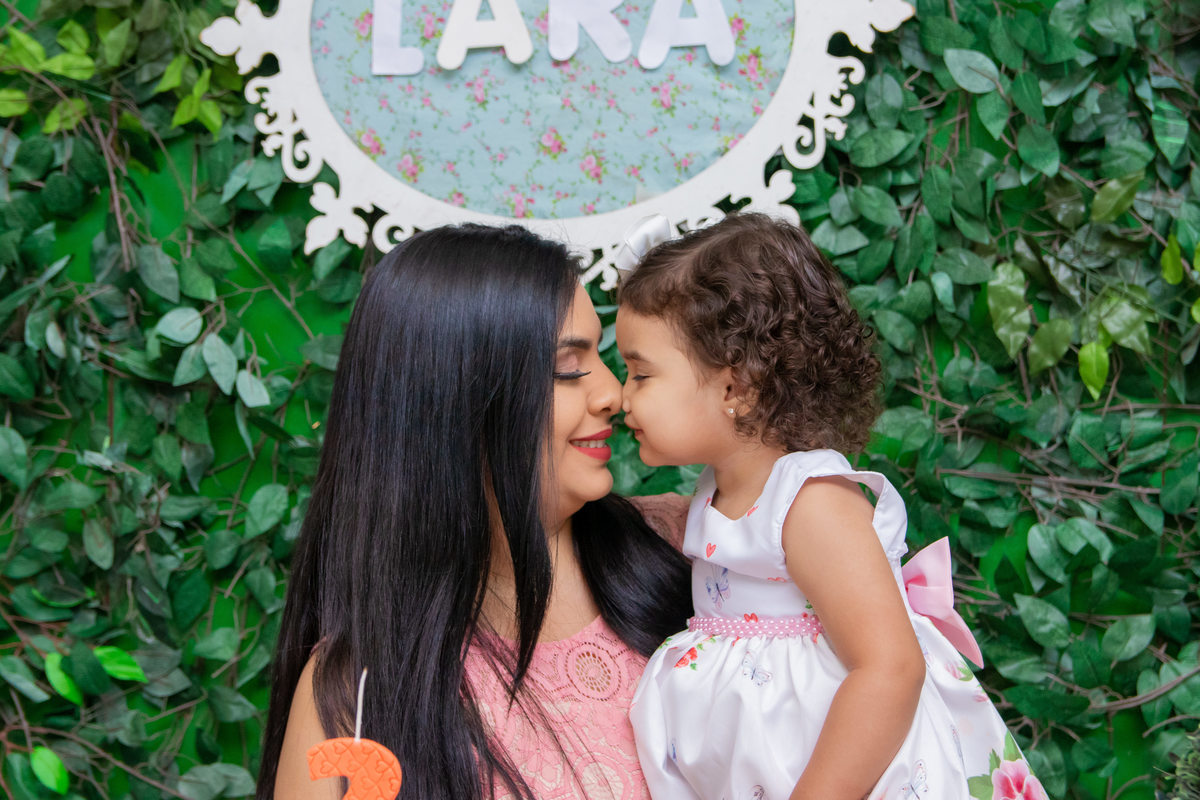 Mãe e aniversariante na mesa do bolo