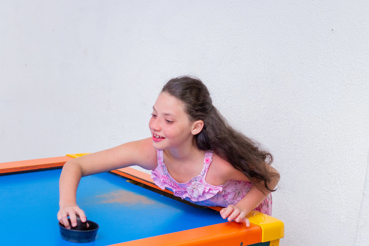 Menina brincando no air hockey
