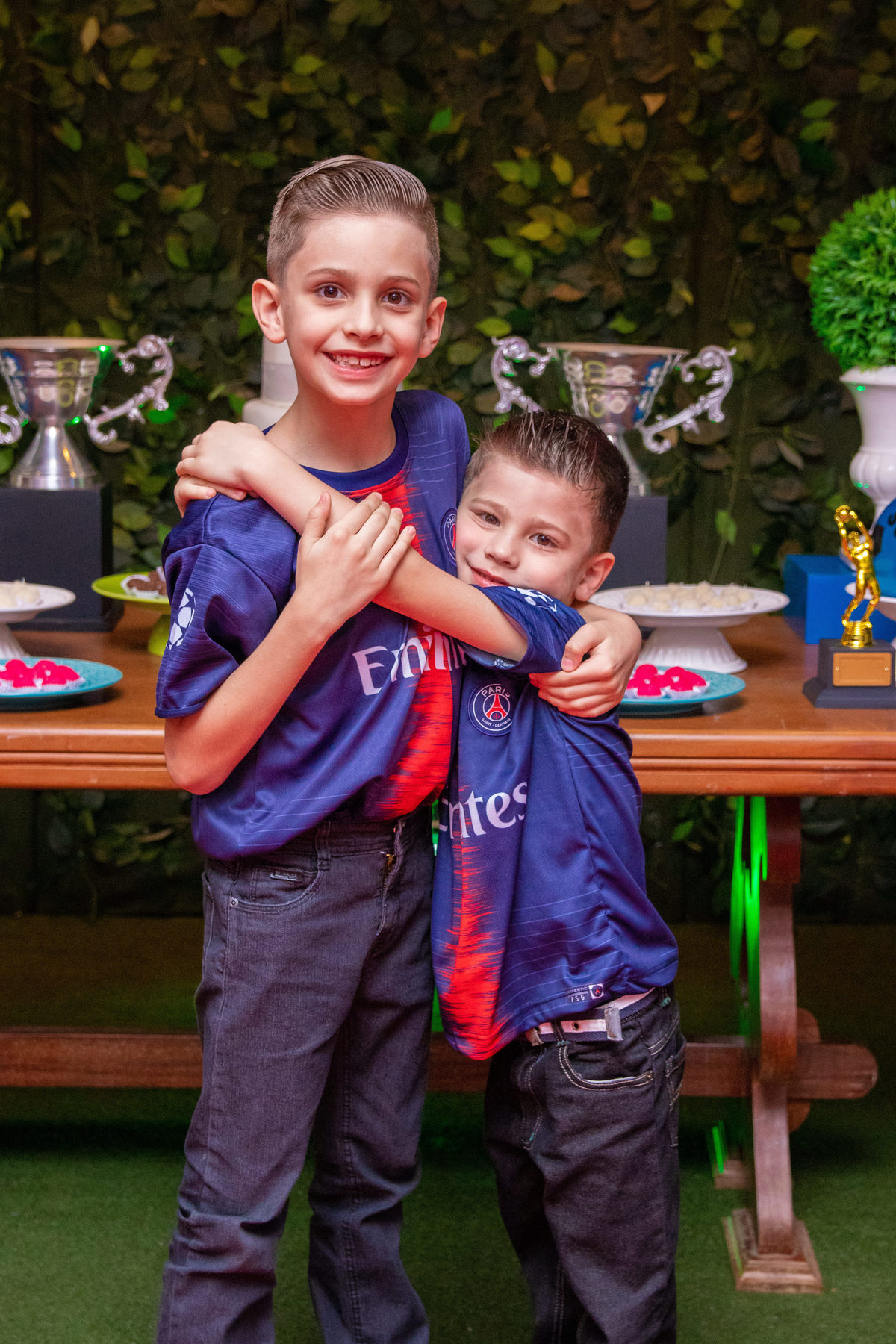 Aniversariante e seu irmão na mesa do bolo