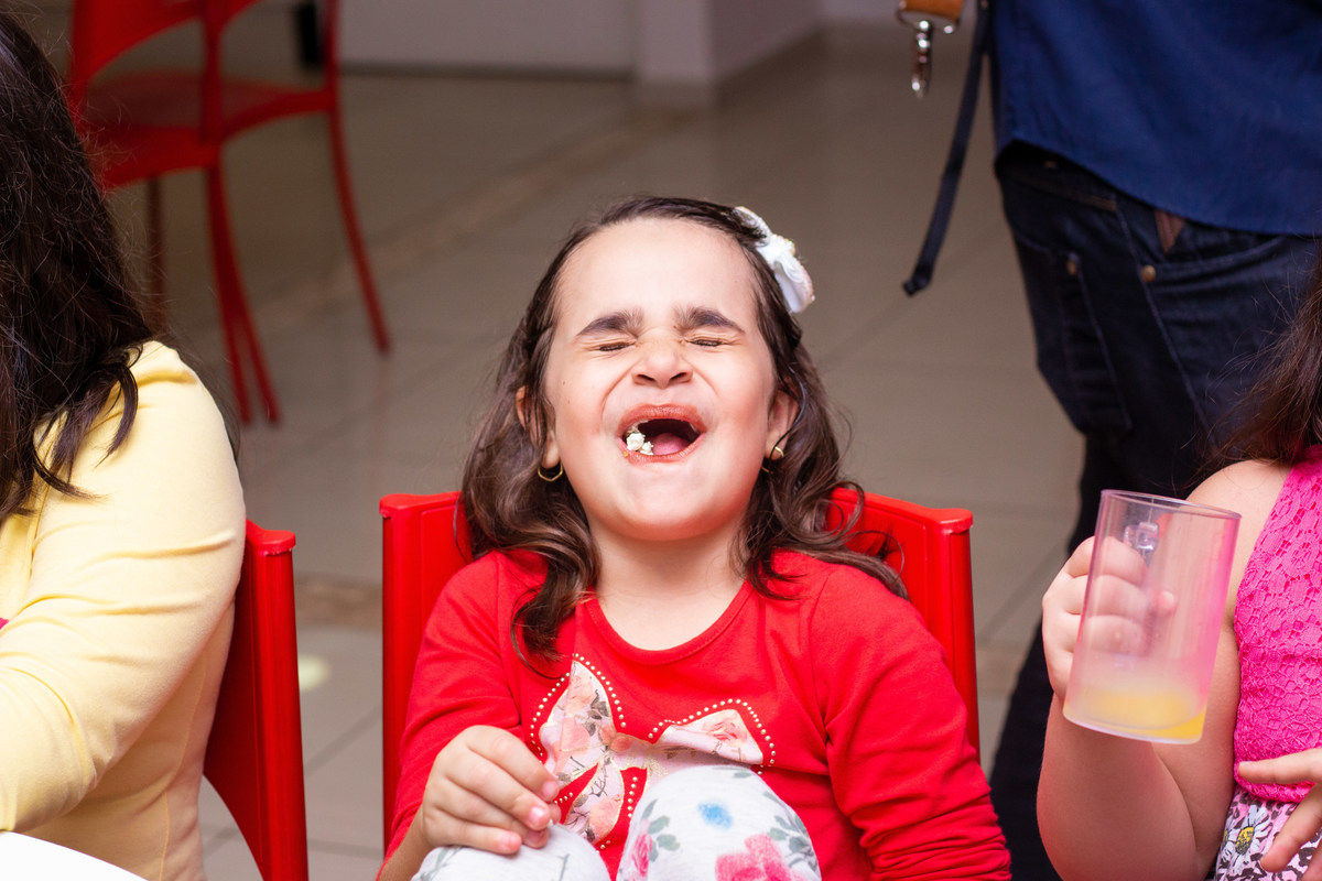 Menina feliz comendo pipoca