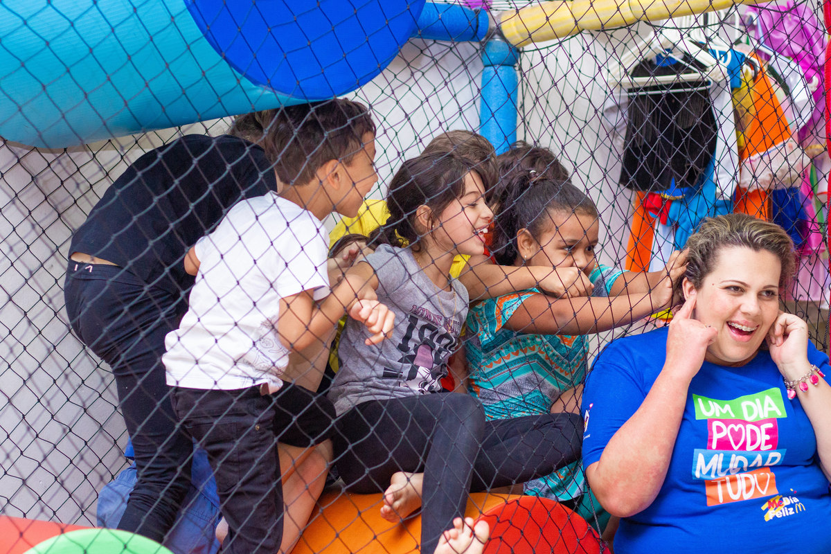 Crianças brincando com a monitora em aniversário