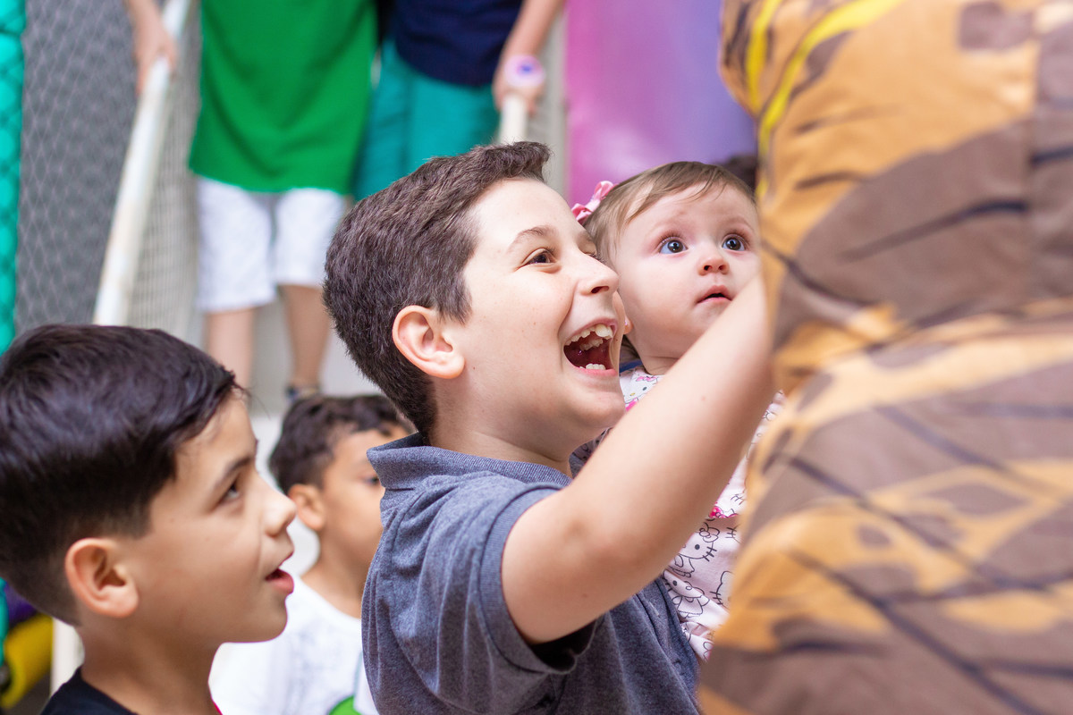 Menino sorrindo para o dinossauro