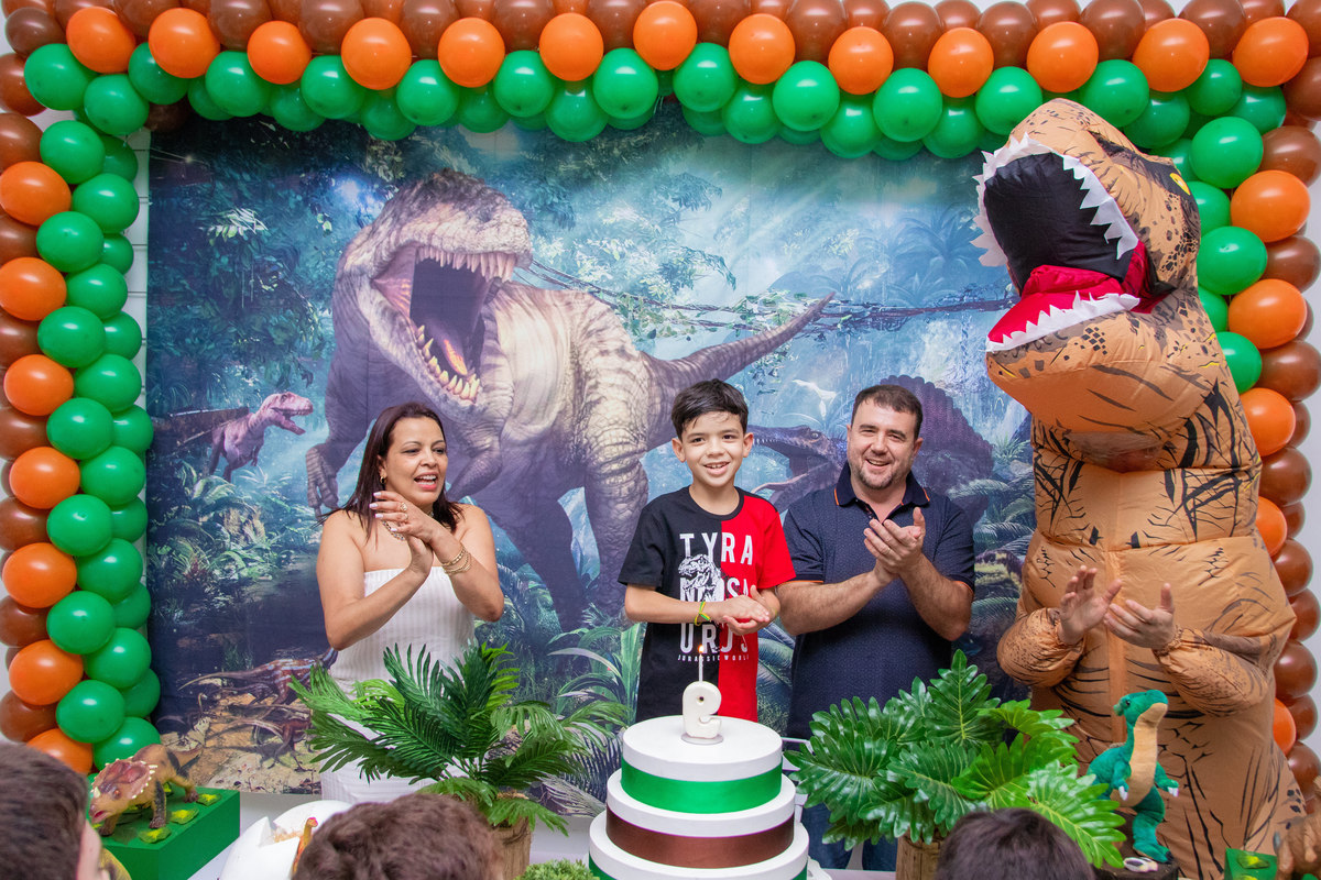 Aniversariante e sua família na mesa do bolo na hora do parabéns