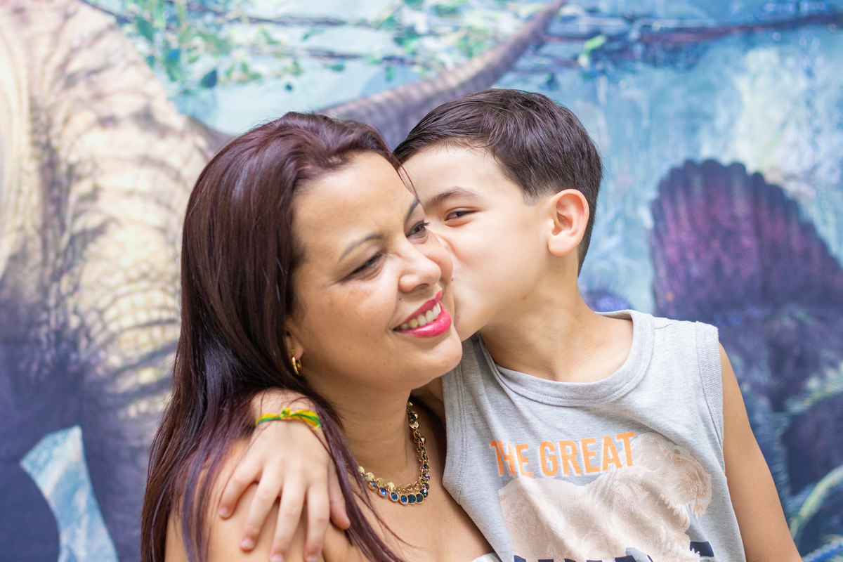 Aniversariante e sua mãe na mesa do bolo