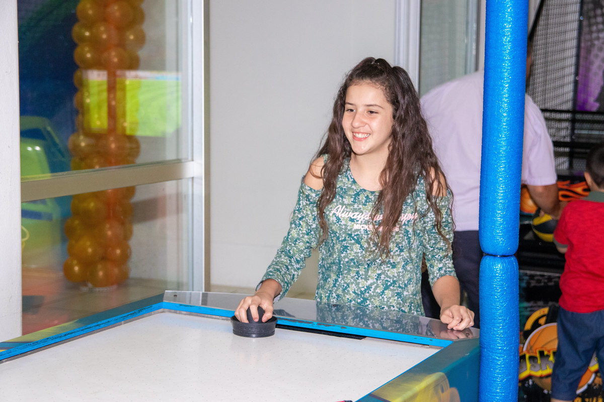 Menina brincando no air hockey 