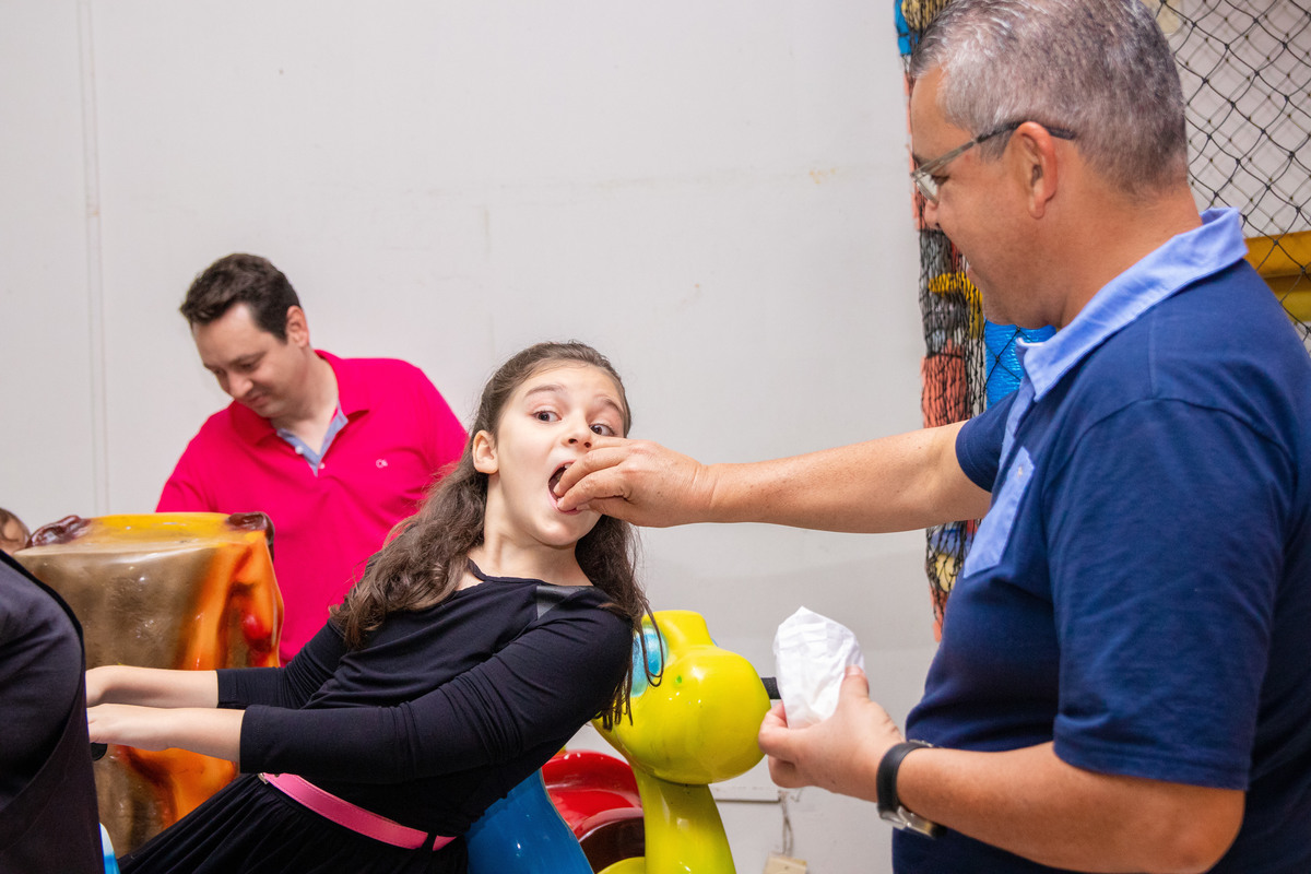 Pai dando pipoca para a filha em aniversário