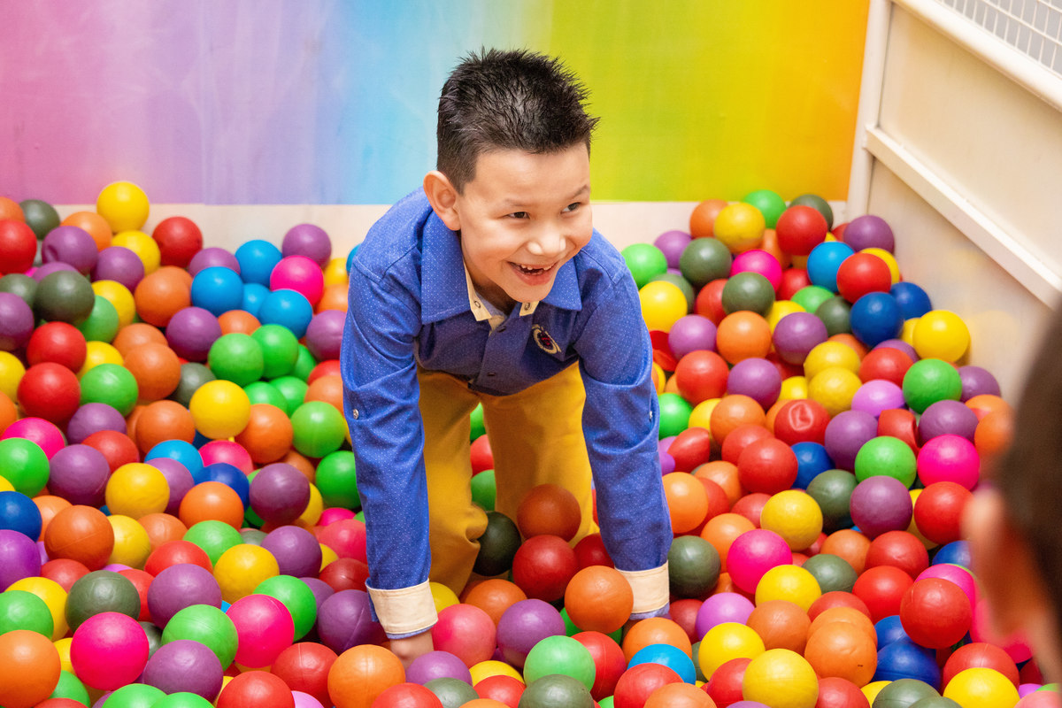 Menino brincando na piscina de bolinha