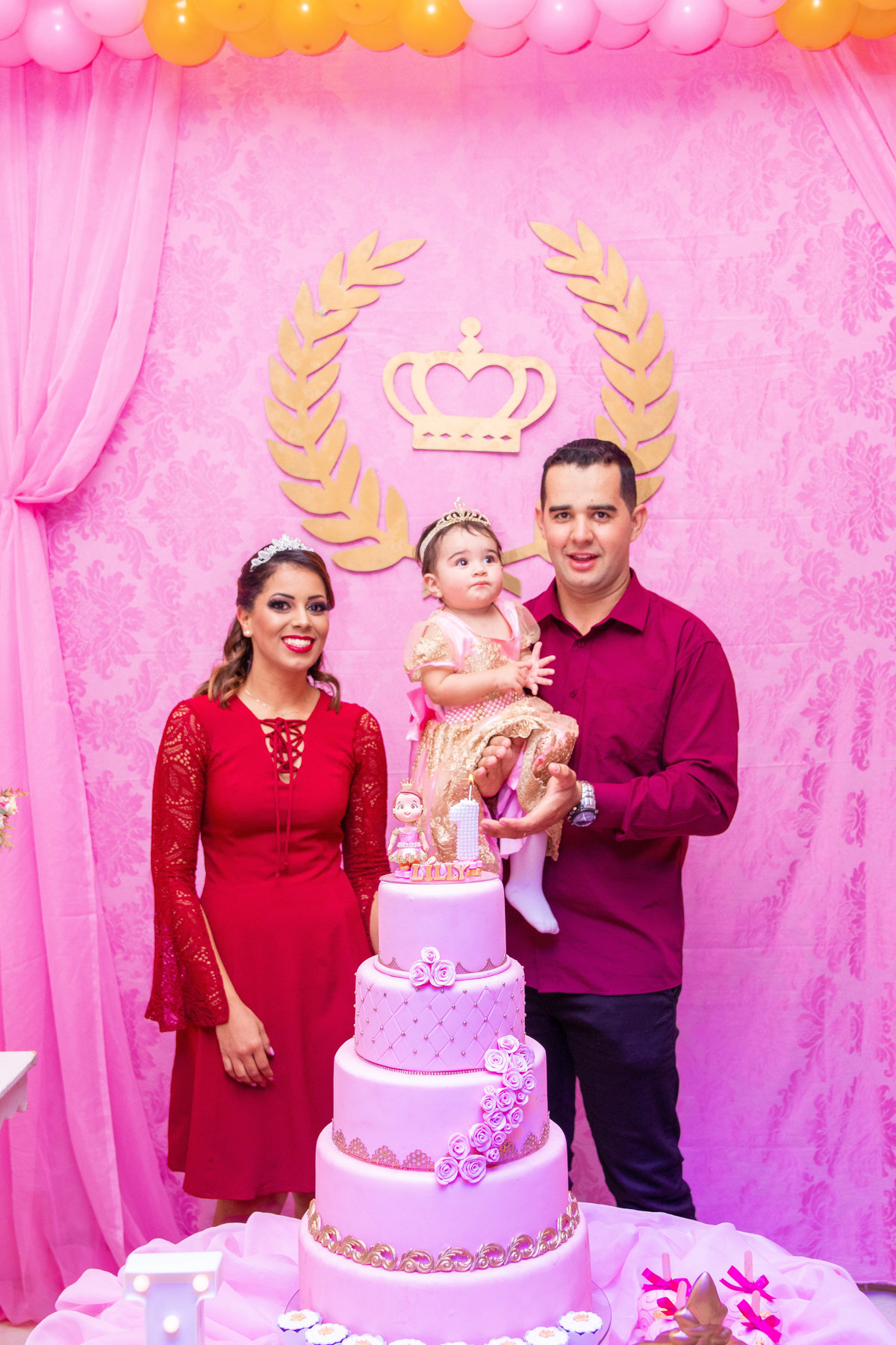 Pais e aniversariante na mesa do bolo cantando parabéns