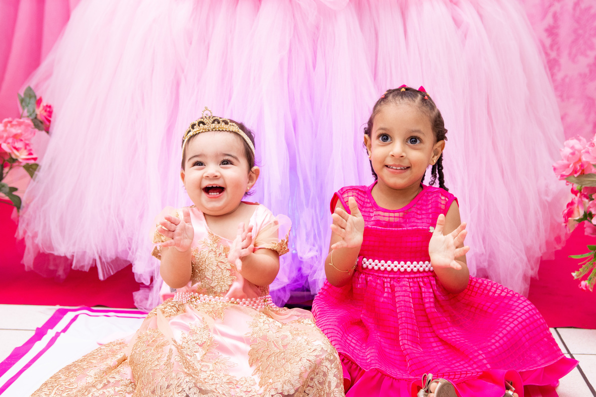 Aniversariante e amiga sorrindo e batendo palmas em seu aniversário