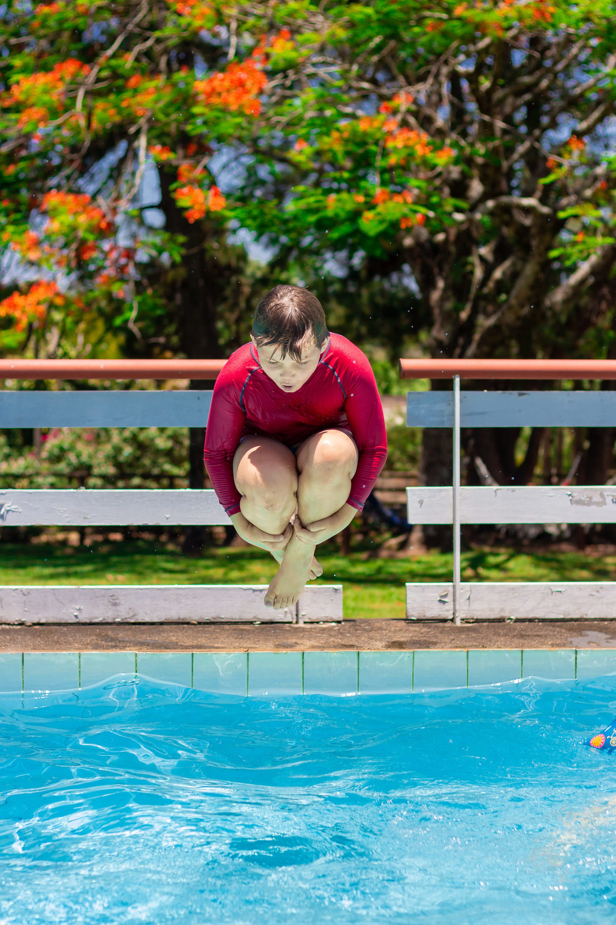 menino pulando na piscina em aniversário