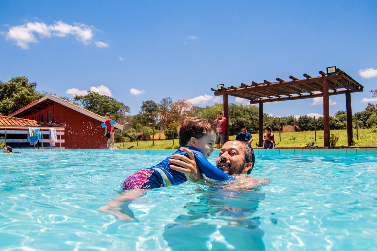 pai e aniversariante brincando na piscina