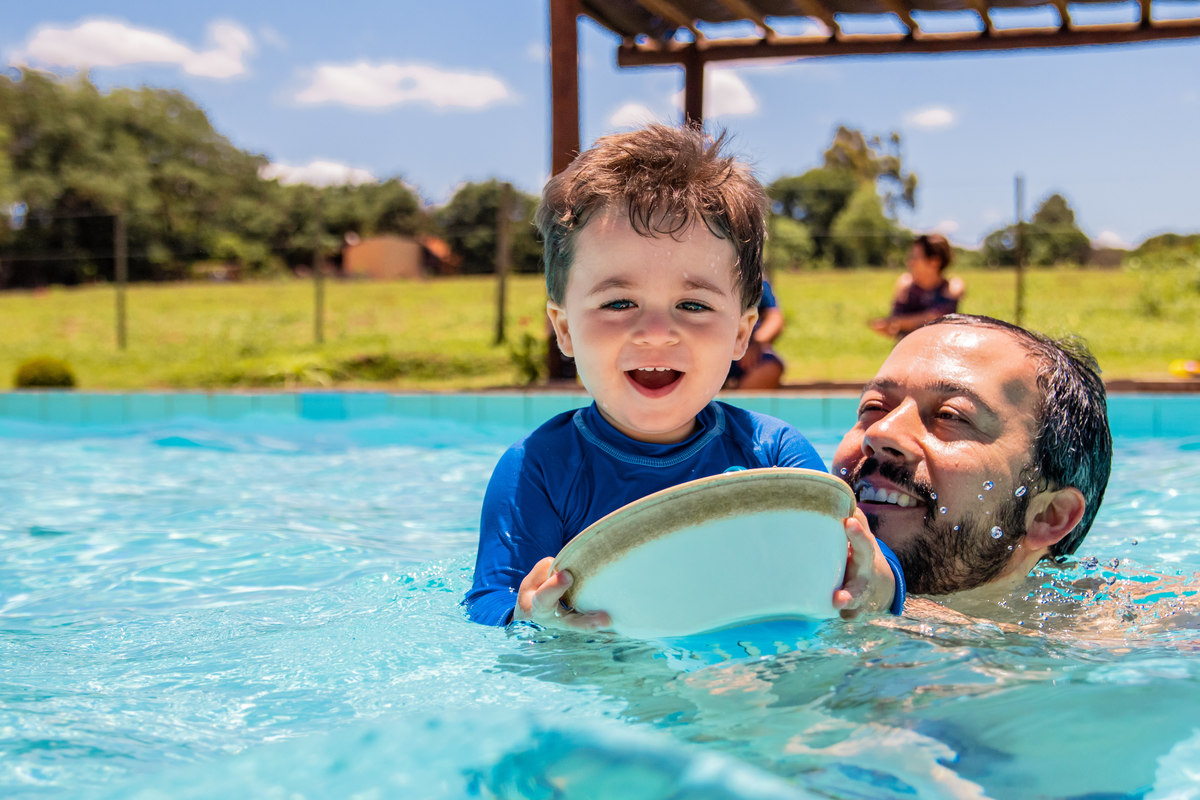 pai e filho brincando na piscina em seu aniversário