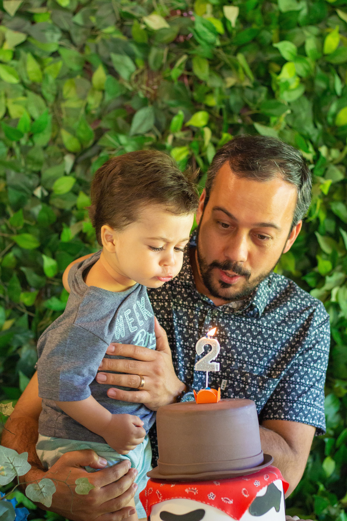 Pai e aniversariante assoprando as velinhas