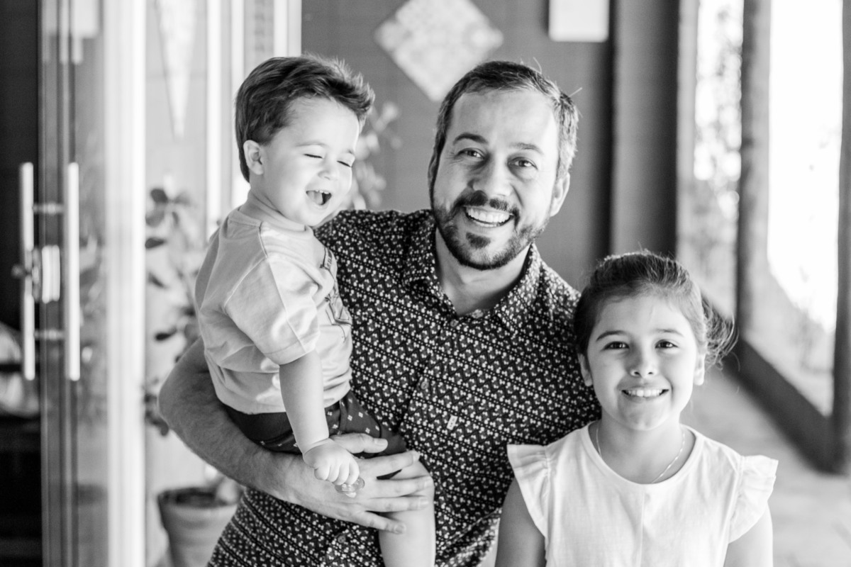 Aniversariante, pai e prima sorrindo em seu aniversário