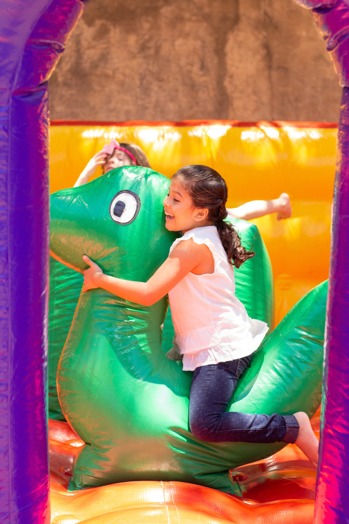 criança brincando em dinossauro inflável 